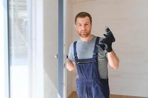 une ouvrier installe les fenêtres dans une Nouveau modulaire maison. le concept de une Nouveau maison. photo