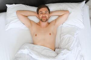 content Jeune barbu homme est relaxant sur le lit à Accueil photo