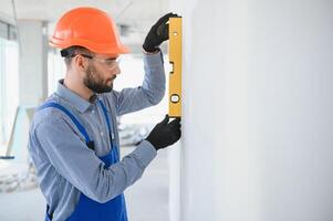 construction ouvrier dans bleu uniforme avec esprit niveau photo