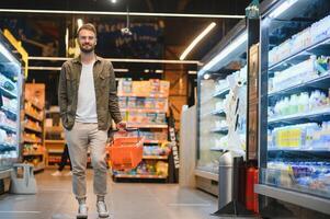 Beau Jeune homme choisir nourriture dans le supermarché. photo