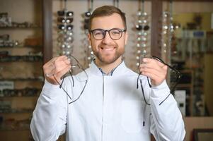 Beau ophtalmologiste en portant lunettes pour une essayer dehors. optométriste offre à porter une paire de lunettes. photo