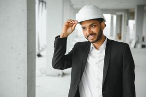 Indien construction site directeur permanent portant casque, en pensant à construction placer. portrait de mixte course Manuel ouvrier ou architecte. photo