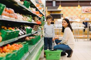 mère et sa fils achat des fruits à une Les agriculteurs marché photo