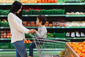 mère et sa fils achat des fruits à une Les agriculteurs marché photo