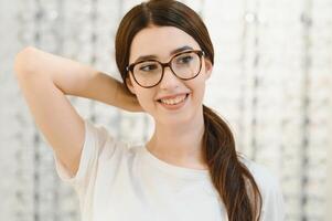 femme choisit des lunettes dans le magasin. photo