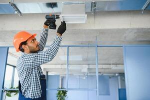 HVAC prestations de service - Indien ouvrier installer canalisé tuyau système pour ventilation et air conditionnement dans maison photo