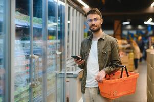 Beau homme achats dans une supermarché photo