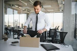 mis à la porte Jeune homme emballage le sien des trucs dans Bureau photo