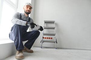 plâtrier dans bleu travail uniforme plâtrage le mur à l'intérieur photo