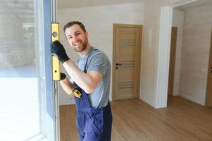 une ouvrier installe les fenêtres dans une Nouveau modulaire maison. le concept de une Nouveau maison. photo