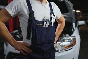 main avec clé. auto mécanicien dans voiture réparation . photo