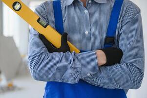 construction ouvrier dans bleu uniforme avec esprit niveau photo