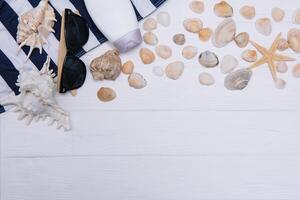 plage accessoires. serviette, tongs, étoile de mer, bateau et des lunettes de soleil sur en bois Contexte. Haut vue avec copie espace. ensoleillé tonique photo