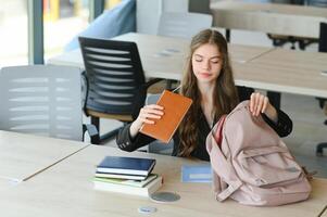 adolescent fille en train d'étudier avec cahier de texte l'écriture rédaction apprentissage dans Salle de classe. photo