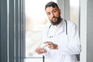 portrait de agréable Jeune arabe médecin dans blanc manteau. photo