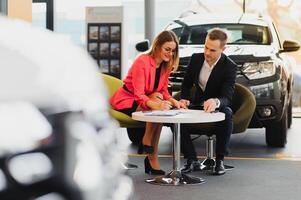 magnifique Jeune femme achète une voiture dans le concession salon. photo