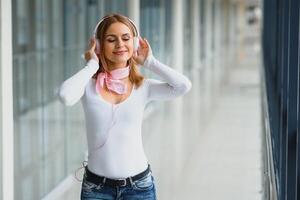 élégant fille écoute à la musique rose écouteurs photo
