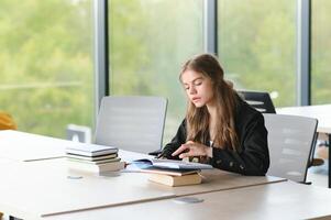 adolescent fille en train d'étudier avec cahier de texte l'écriture rédaction apprentissage dans Salle de classe. photo