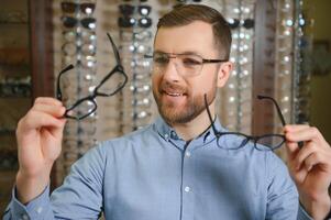 satisfait client. plus de le épaule vue de content Jeune Masculin client portant Nouveau lunettes. photo