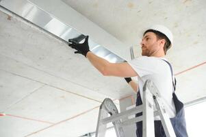 HVAC prestations de service - ouvrier installer canalisé tuyau système pour ventilation et air conditionnement photo