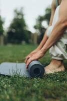 fille pose en dehors une yoga tapis dans le parc photo