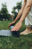 fille pose en dehors une yoga tapis dans le parc photo