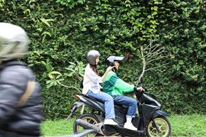 femelle passager montrant direction à en ligne moto chauffeur photo