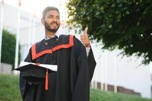 Beau Indien diplômé dans l'obtention du diplôme lueur avec diplôme. photo