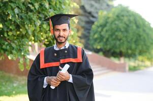 Beau Indien diplômé dans l'obtention du diplôme lueur avec diplôme. photo