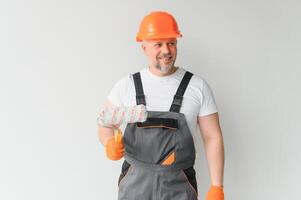 homme supporter dans le pièce avec peindre rouleau dans le sien main photo