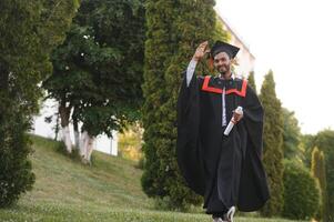 portrait de réussi Indien étudiant dans l'obtention du diplôme robe. photo