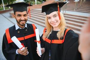 éducation, l'obtention du diplôme et gens concept - groupe de content international étudiants. photo