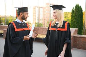 éducation, l'obtention du diplôme et gens concept - content international élèves dans mortier planches et bachelier robes. photo