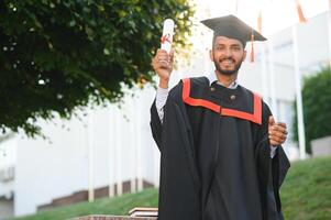 Beau Indien diplômé dans l'obtention du diplôme lueur avec diplôme. photo