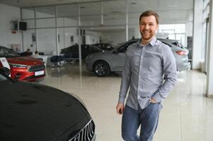 une homme choisit une Nouveau voiture pour lui-même des promenades entre le Lignes dans une voiture concession photo