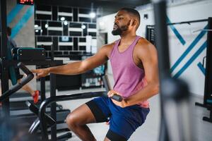 africain homme en utilisant Stationnaire vélo dans une Gym photo