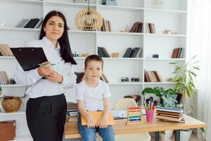 tuteur offres avec le enfant d'âge préscolaire avec une ordinateur portable, une réel Accueil intérieur, le concept de enfance et apprentissage photo