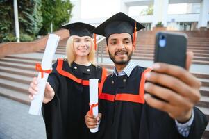 éducation, l'obtention du diplôme et gens concept - groupe de content international étudiants. photo