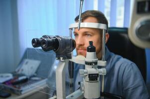 ophtalmologie concept. Masculin patient en dessous de œil vision examen dans vue ophtalmologique correction clinique photo