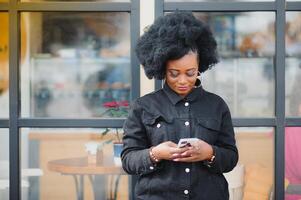 Extérieur proche en haut portrait de Jeune mignonne content souriant africain américain femme avec afro coiffure. photo