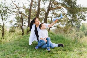 élégant mère et Beau fils ayant amusement sur le la nature. content famille concept. beauté la nature scène avec famille Extérieur mode de vie. content famille repos ensemble. bonheur dans famille vie. les mères journée. photo