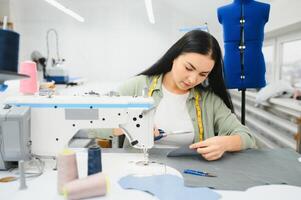 positif Jeune femme couture avec professionnel machine à atelier. photo