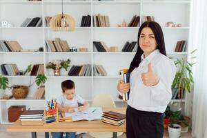 tuteur offres avec le enfant d'âge préscolaire avec une ordinateur portable, une réel Accueil intérieur, le concept de enfance et apprentissage photo