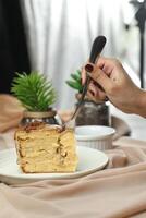 salé caramel blondie gâteau tranche comprendre Chocolat crème, sucre avec fourchette, tasse de café et pot servi assiette isolé sur serviette de table côté vue de café nourriture photo