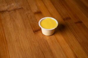 mon chéri moutarde tremper servi dans tasse isolé sur en bois table Haut vue de Indien nourriture photo