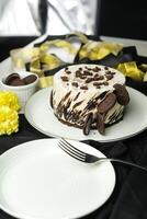 oreo cheesecake comprendre chocolat, crème, sucre avec fourchette et fleurs servi dans assiette isolé sur serviette de table côté vue de café nourriture photo