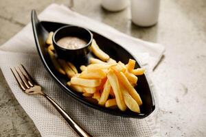 français frites avec mayo tremper servi dans une plat isolé sur gris Contexte côté vue vite nourriture photo