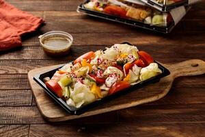 vert salade avec tomate, concombre et sauce servi dans une plat isolé sur en bois table Contexte côté vue de Fast food photo