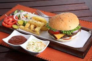 grillé angus du boeuf Burger avec frites, salade et tomate sauce servi dans une plat isolé sur table côté vue de milieu est nourriture photo