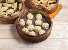 Fait main à la vapeur Dumplings et frit boulette ou momo servi dans en bois plat isolé sur table Haut vue Japonais nourriture photo